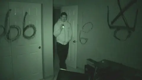 Investigador dentro de la casa endemoniada Investigador dentro de la casa endemoniada