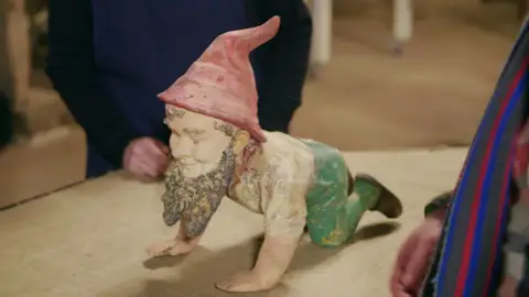 Este gnomo de jardín ha sufrido numerosas reparaciones que han afectado a su imagen final Este gnomo de jardín ha sufrido numerosas reparaciones que han afectado a su imagen final